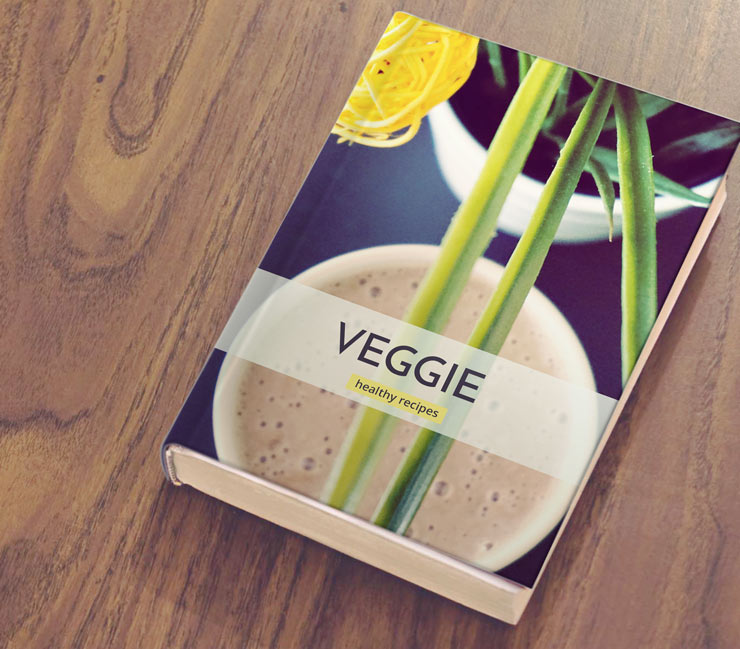 Veggie cookbook on wooden table.
