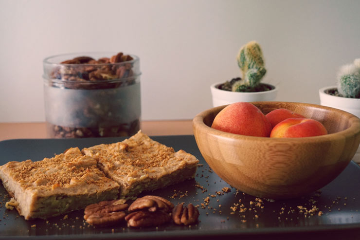 Peach bowl and pecan bars on table.